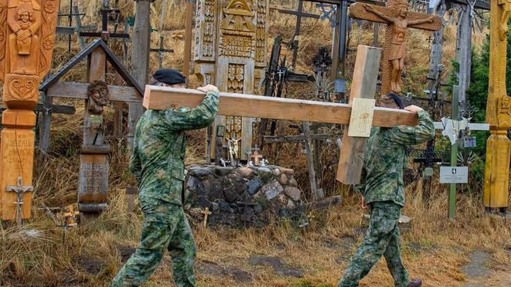 2 militairen dragen groot houten kruis.