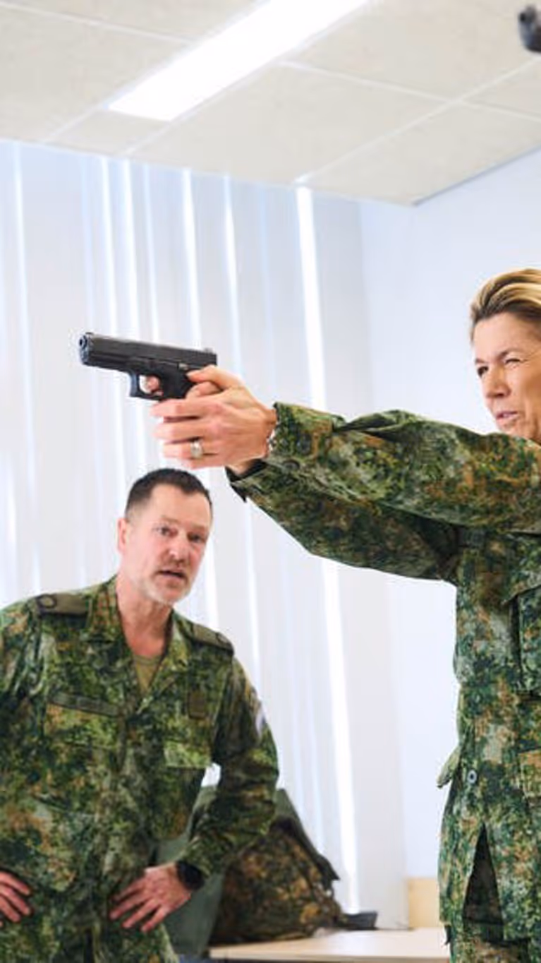 Alt-tekst: Koningin Maxima richt een wapen. 