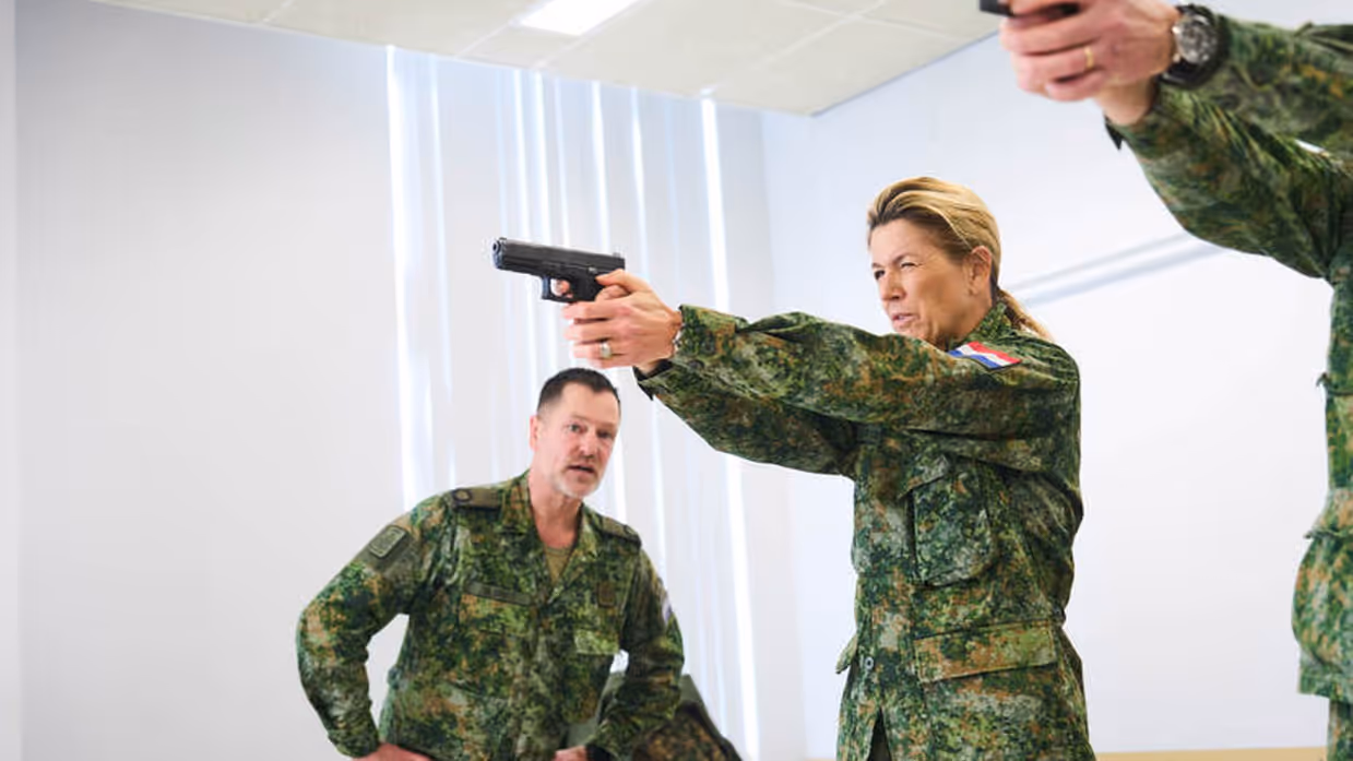 Koningin Máxima oefent met een pistool.