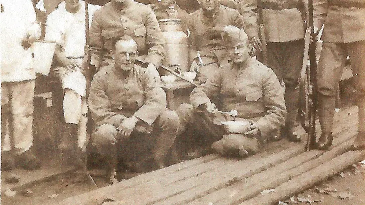 Historische groepsfoto militairen tijdens etenstijd.