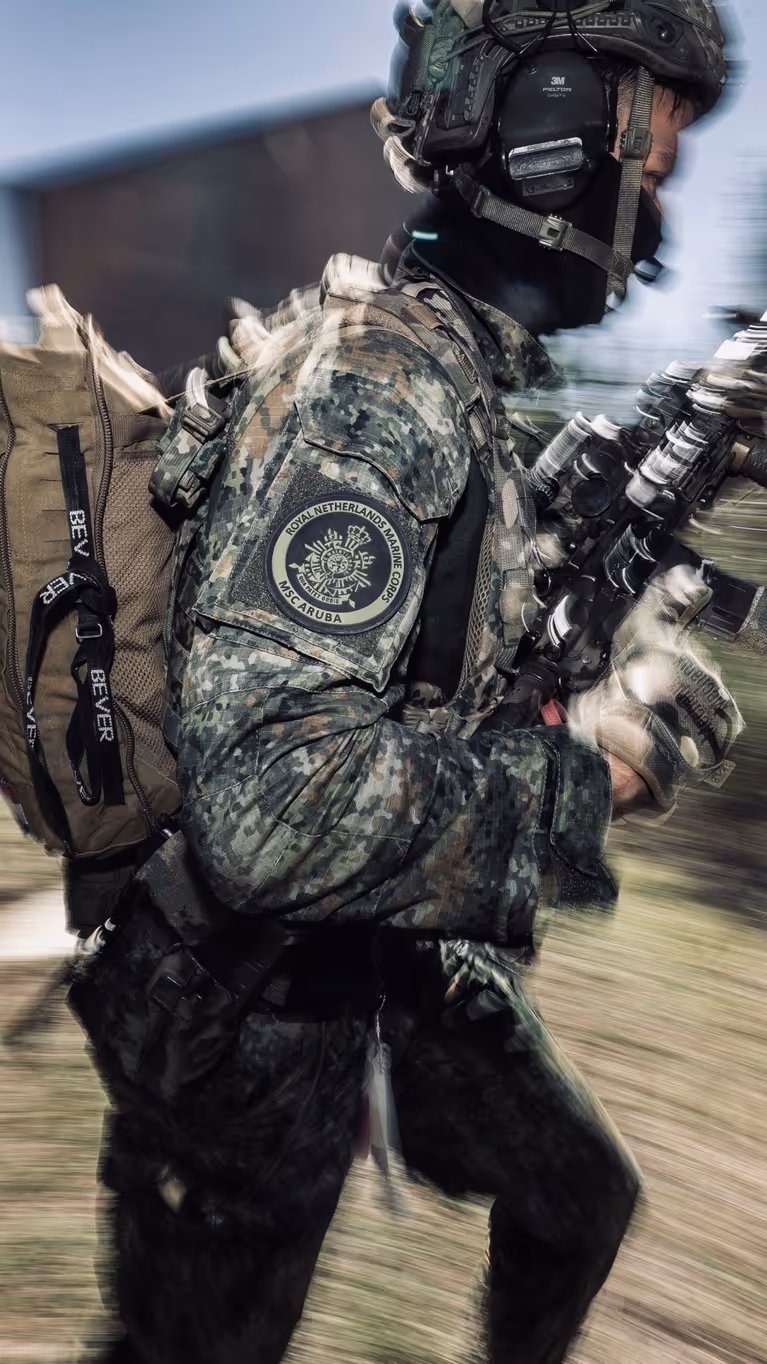 Een marinier gaat met zichtbare snelheid door een kamer van een oefenhuis.    