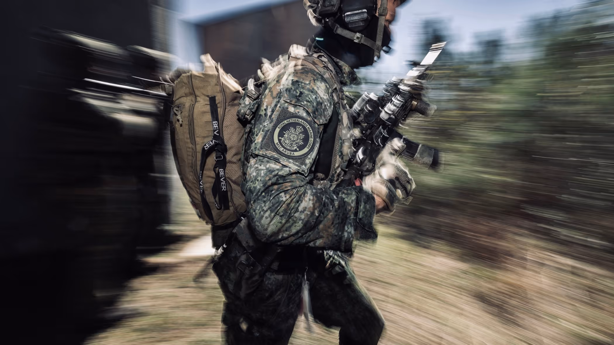 Een marinier gaat met zichtbare snelheid door een kamer van een oefenhuis.    