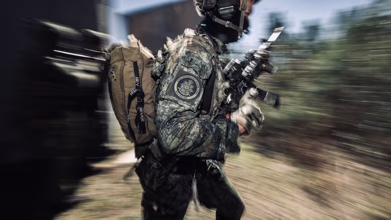 Een marinier gaat met zichtbare snelheid door een kamer van een oefenhuis.    