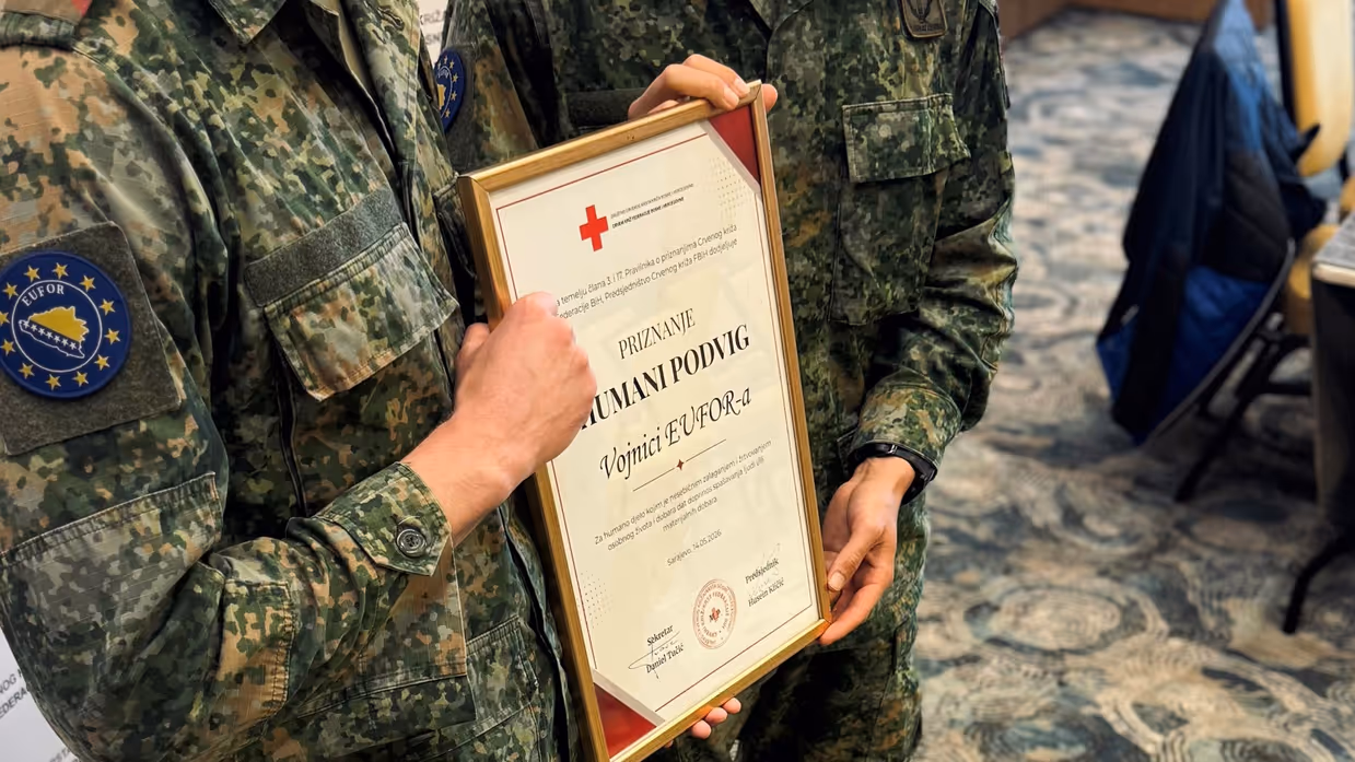 Twee militairen houden een plaquette vast.