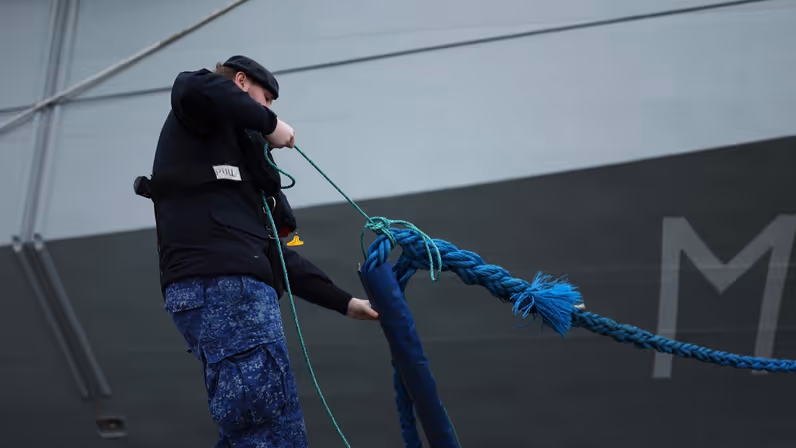 Een militair haalt een touw naar binnen.