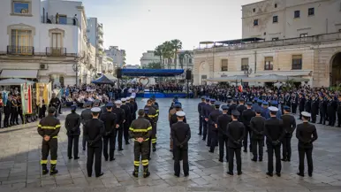 Italiaans plein met diverse groepen opgestelde militairen. Er omheen staat en zit publiek.