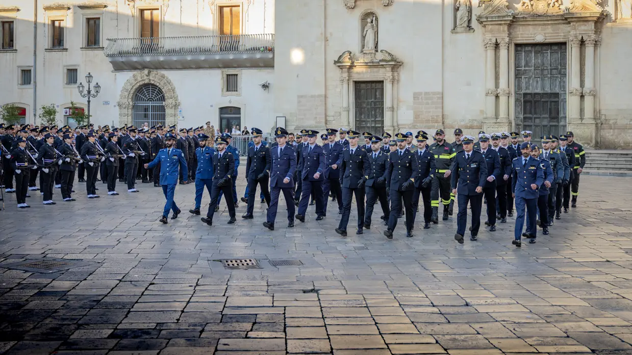 Een groep militairen marcheert een plein op, onder hen Nederlandse luchtmachtmilitairen.