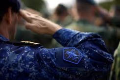 Een militair met het logo van JFC op het uniform brengt een groet uit.