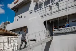 De minister stapt aan boord van een schip.
