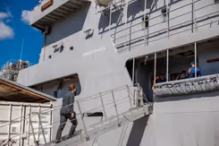 De minister stapt aan boord van een schip.