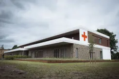 Buitenkant militair Gezondheidscentrum en Tandheelkundig Centrum met rood kruis op de buitenmuur.