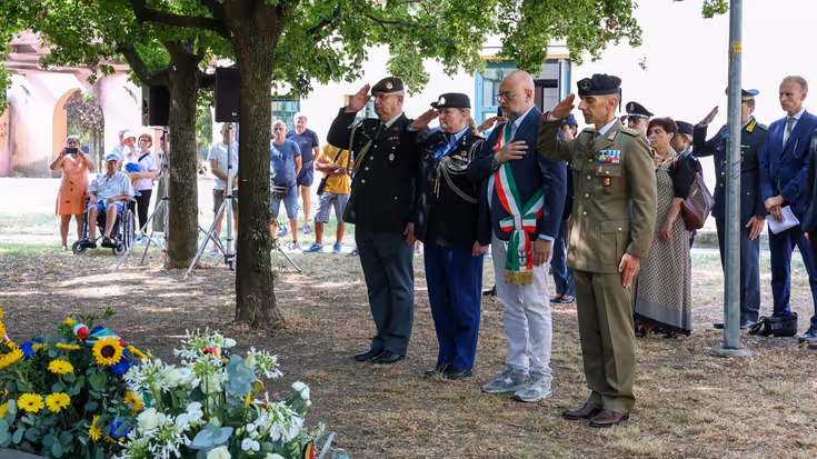 Herdenking, met militairen in de houding en burgers die stilstaan.