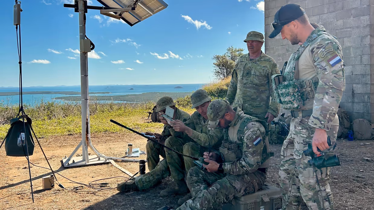 Militairen controleren hun uitrusting in de schaduw.