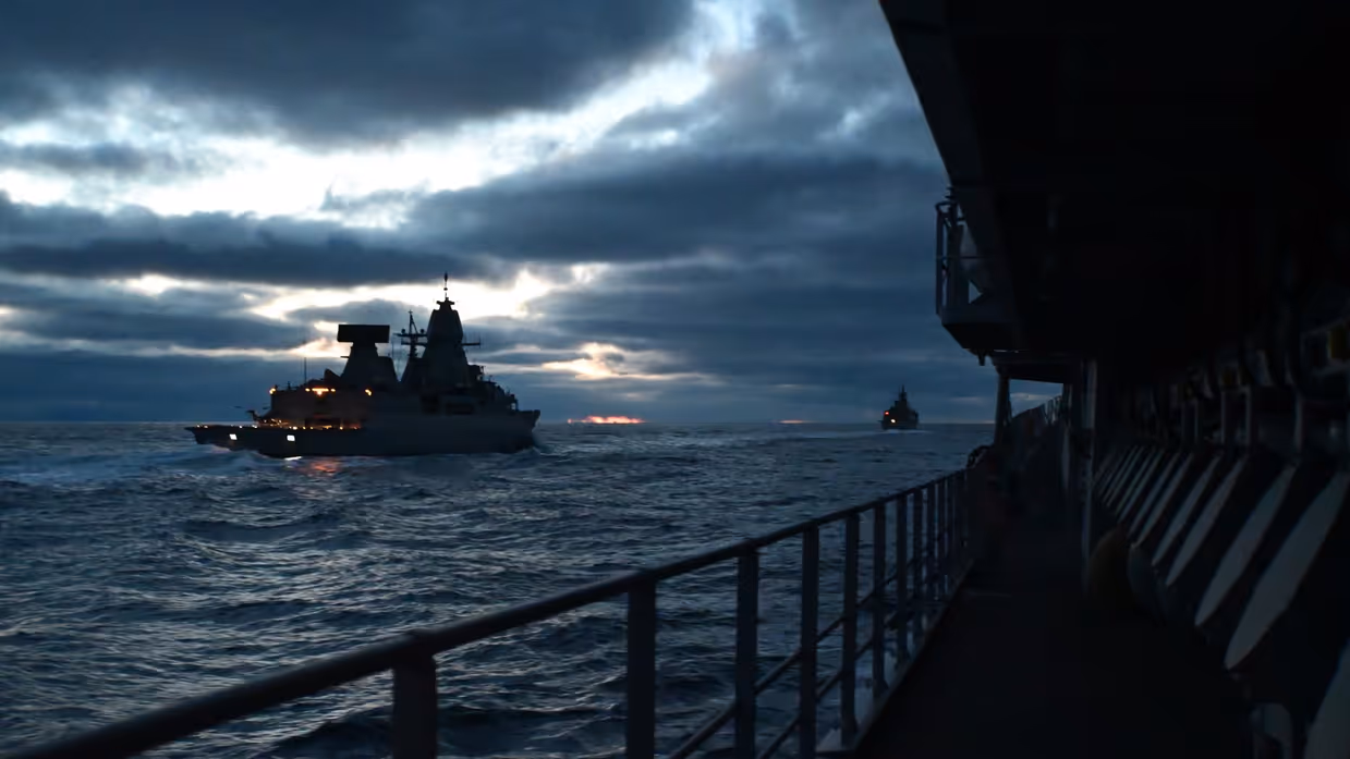 Een militair schip is zichtbaar op het water vanaf een ander schip.