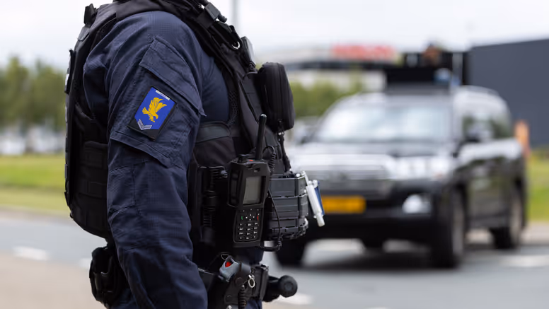 Onherkenbare marechaussee van de GBB voor een voertuig.