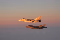 F-35 begeleidt een Russisch vliegtuig in de lucht.