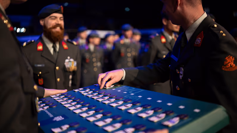Militair staat klaar om medaille in ontvangst te nemen. 