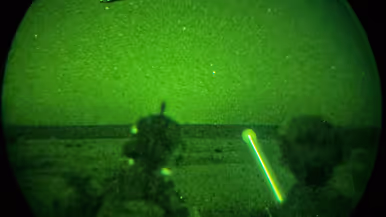 Foto’s van de Live Fire-oefening door een nachtkijker genomen waarbij vanuit een helikopter wordt geschoten.