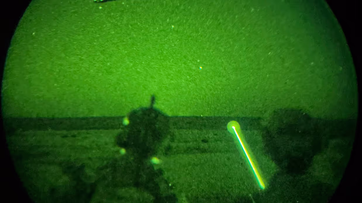 Foto’s van de Live Fire-oefening door een nachtkijker genomen waarbij vanuit een helikopter wordt geschoten.