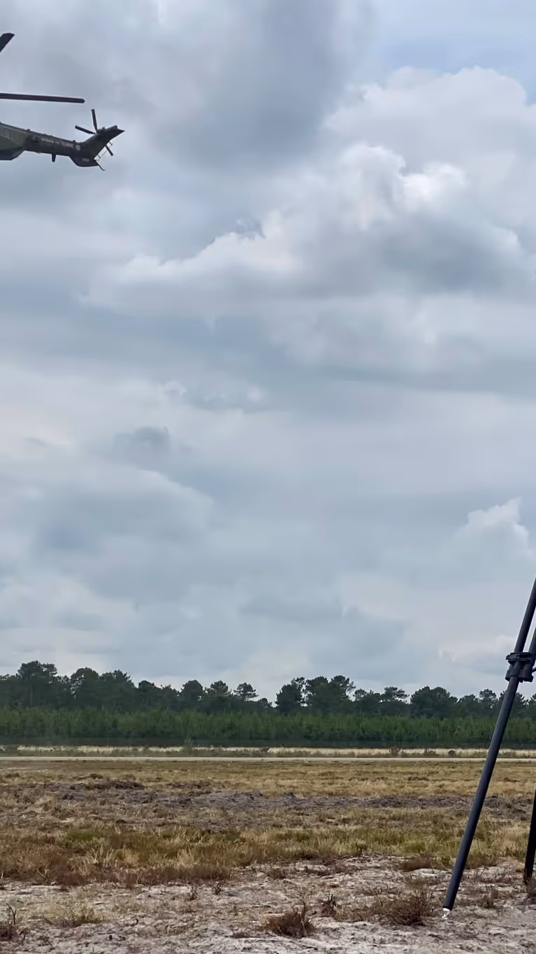 Op de voorgrond een radar, op de achtergrond militairen die met een touw afdalen uit een helikopter. 