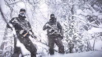 2  militairen in besneeuwd bos.