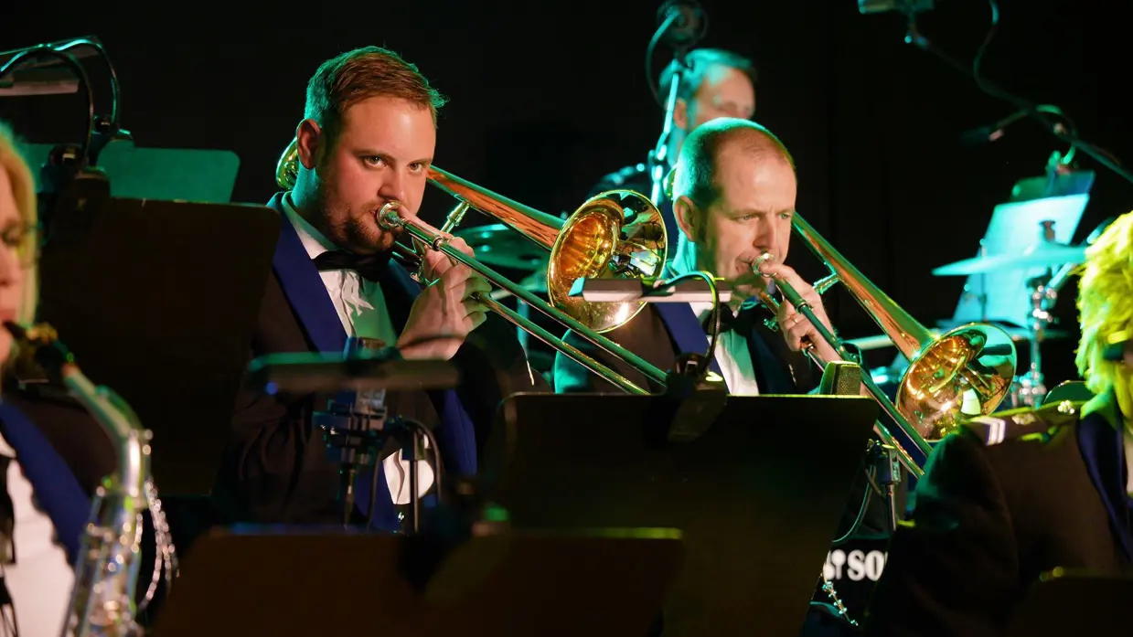Muzikanten van het orkest Koninklijke Marechaussee spelen trompet.