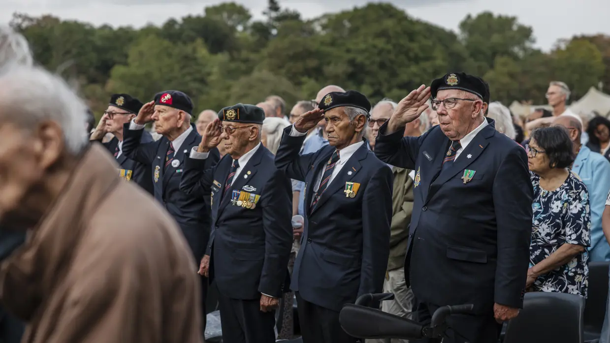Veteranen salueren bij een herdenking.