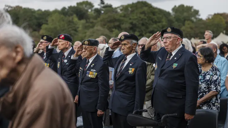 Veteranen salueren bij een herdenking.