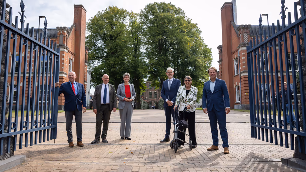 De ondertekenaars staan tussen de poorten van de kazerne. 