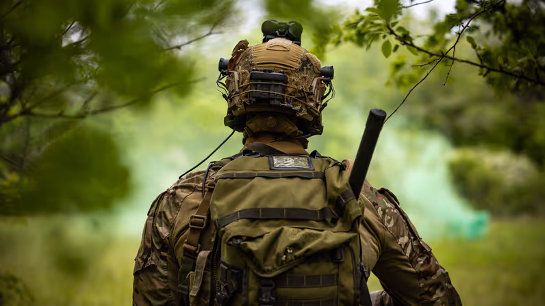 Een KCT’er vanachter vastgelegd. Voor hem een groene rookbom.