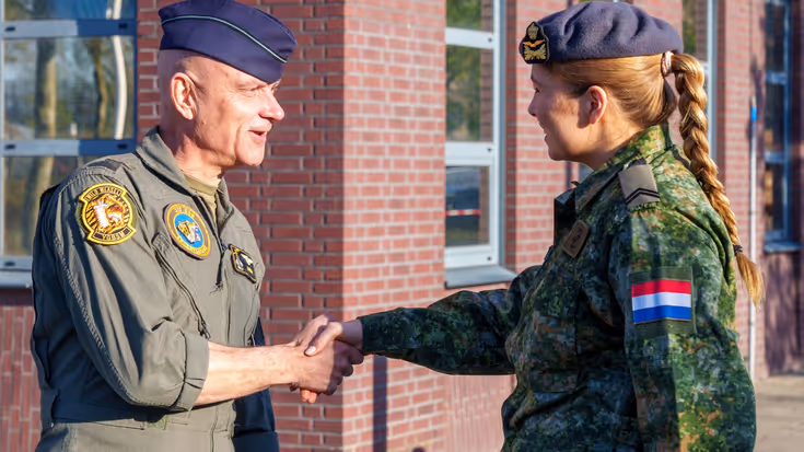De prinses schudt de hand van commandant Koninklijke Luchtmacht luitenant-generaal André Steur.