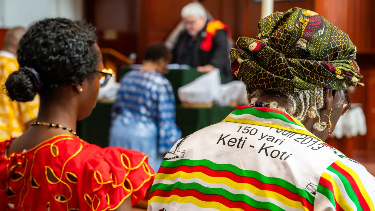 2 vrouwen op de rug gezien tijdens de kerkdienst. 