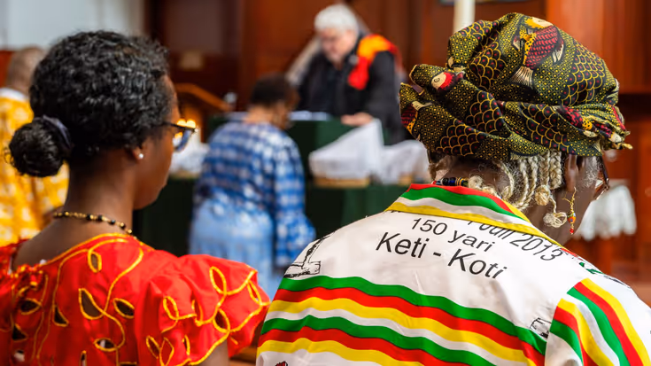 2 vrouwen op de rug gezien tijdens de kerkdienst. 