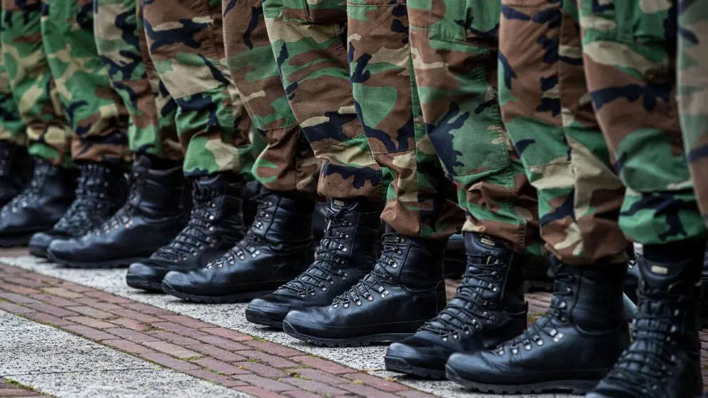 Close-up van voeten en onderbenen gestoken in legerkisten en camouflage kleding.