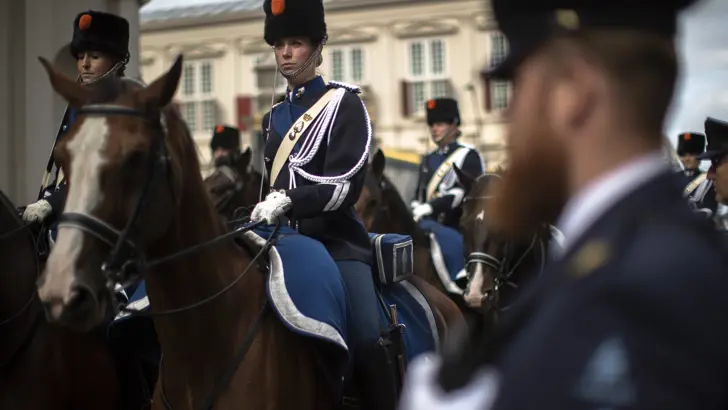 Een vrouwelijke marechaussee in ceremonieel tenue te paard.