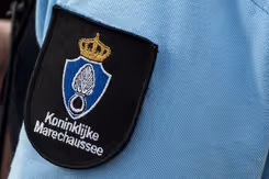 Logo van de marechaussee op de arm van een militair in uniform. 