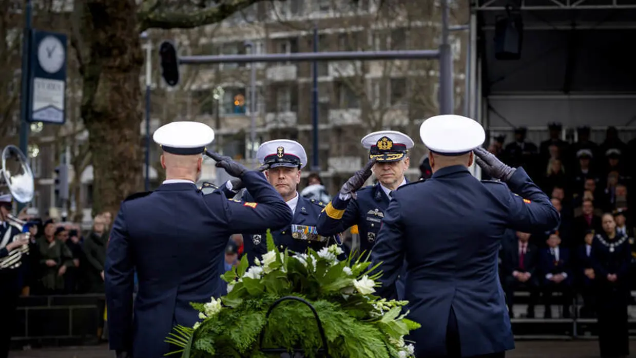 Militairen salueren bij herdenking.