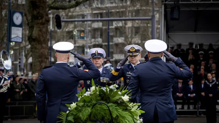 Militairen salueren bij herdenking.