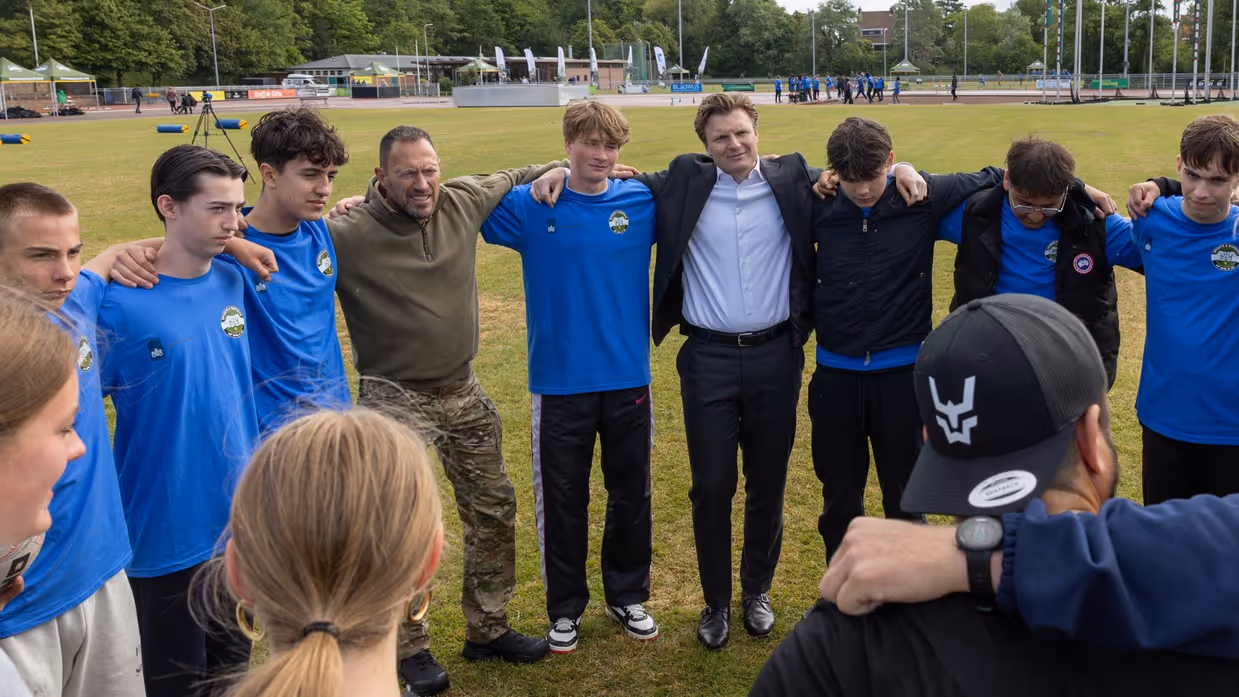 Mensen in een kring, onder wie de minister.