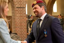 Minister schudt de hand van Wintersberger. Op zijn colbert prijkt het opgespelde kruis.