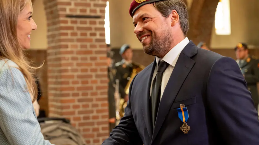 Minister schudt de hand van Wintersberger. Op zijn colbert prijkt het opgespelde kruis.