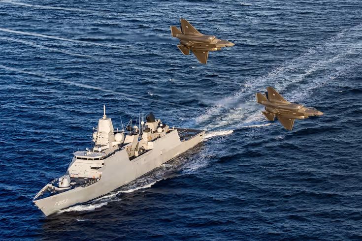 Een LCF op zee, 2 F-35’s vliegen over.