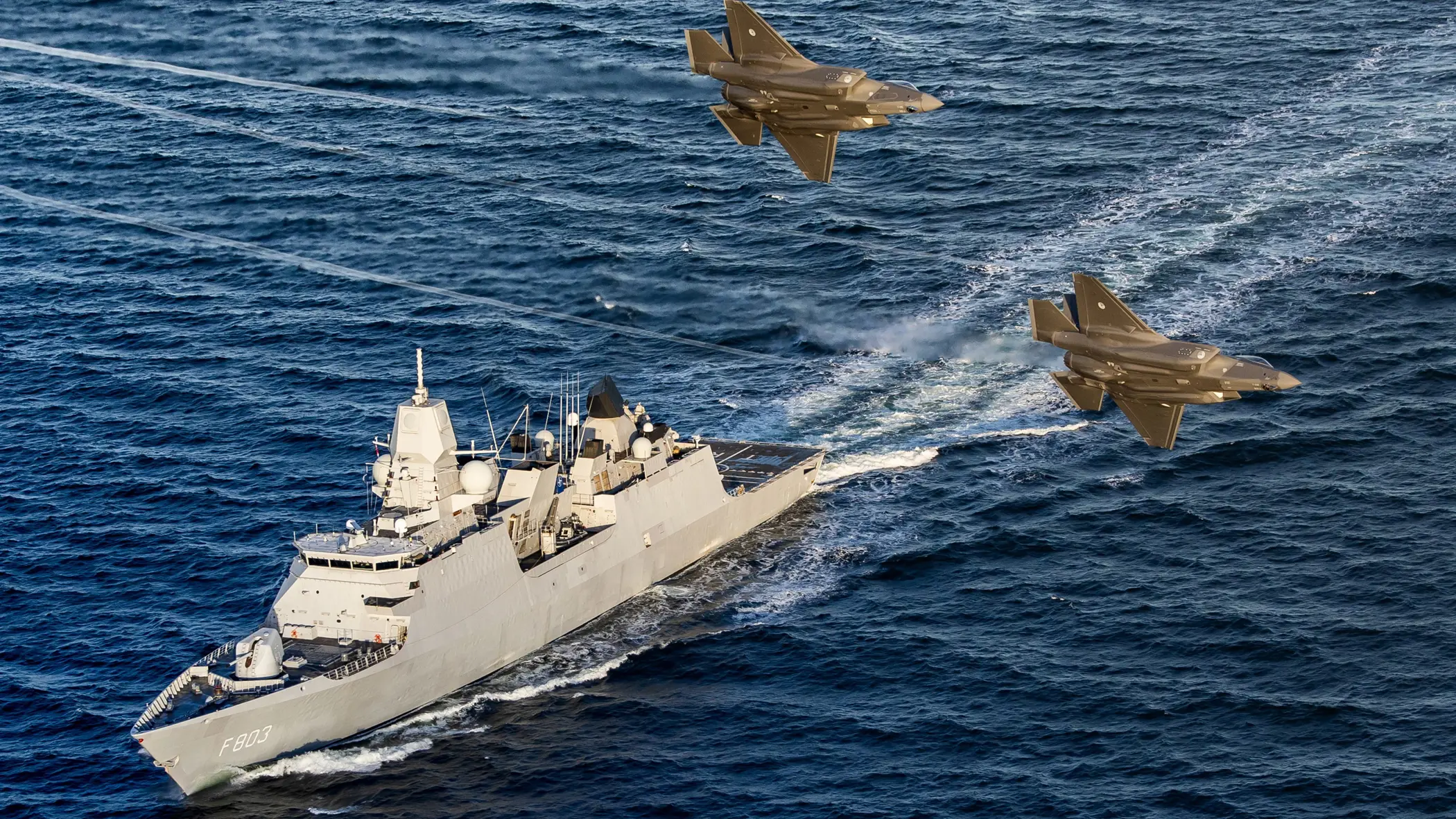 Een LCF op zee, 2 F-35’s vliegen over.