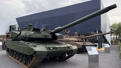  Een overzichtsshot van de Eurosatory met allerlei voertuigen op de voorgrond en de 2A8.