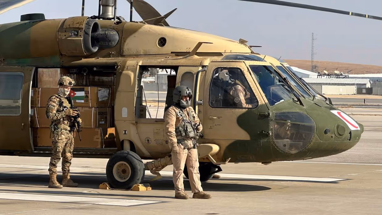 Helikopter met hulpgoederen wordt bewaakt door militairen.