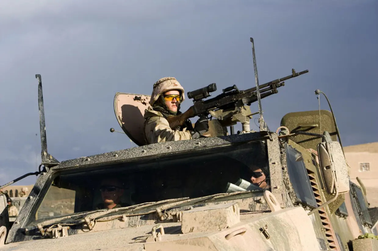 Mag-schutter staat in een Bushmaster achter een machinegeweer.