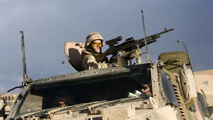 Mag-schutter staat in een Bushmaster achter een machinegeweer.