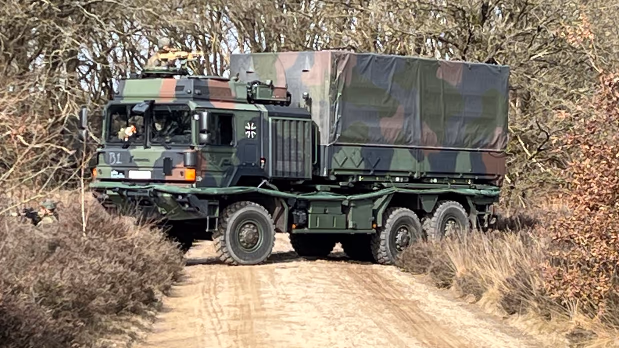  Links: Een militair voertuig probeert te keren, rechts: een militair voertuig rijdt door de bossen.