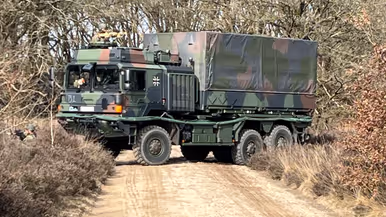  Links: Een militair voertuig probeert te keren, rechts: een militair voertuig rijdt door de bossen.