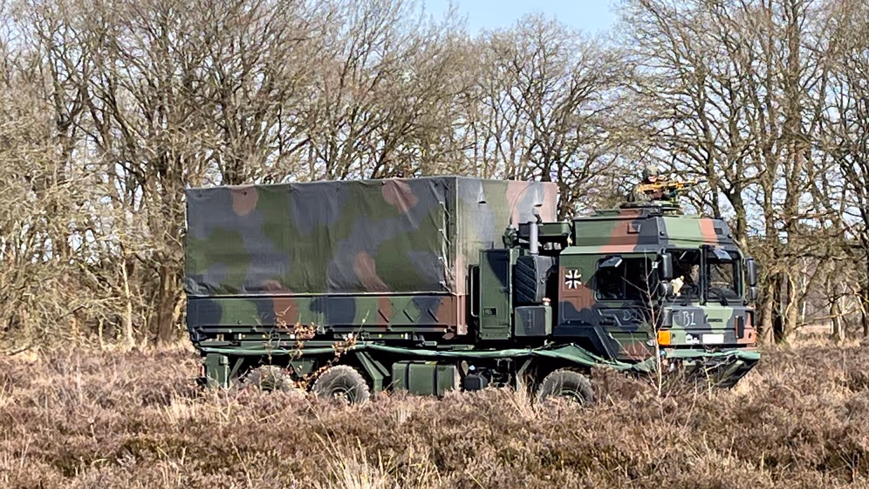  Links: Een militair voertuig probeert te keren, rechts: een militair voertuig rijdt door de bossen.